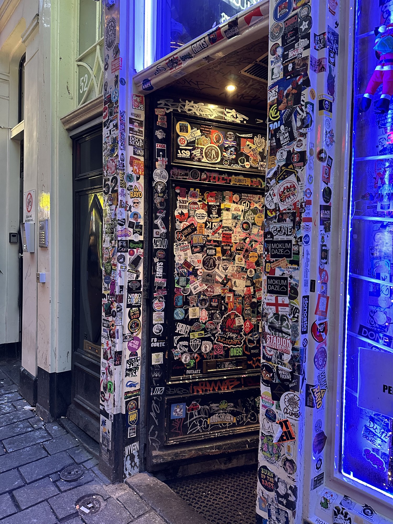 A narrow doorway with walls and door covered floor to ceiling in stickers