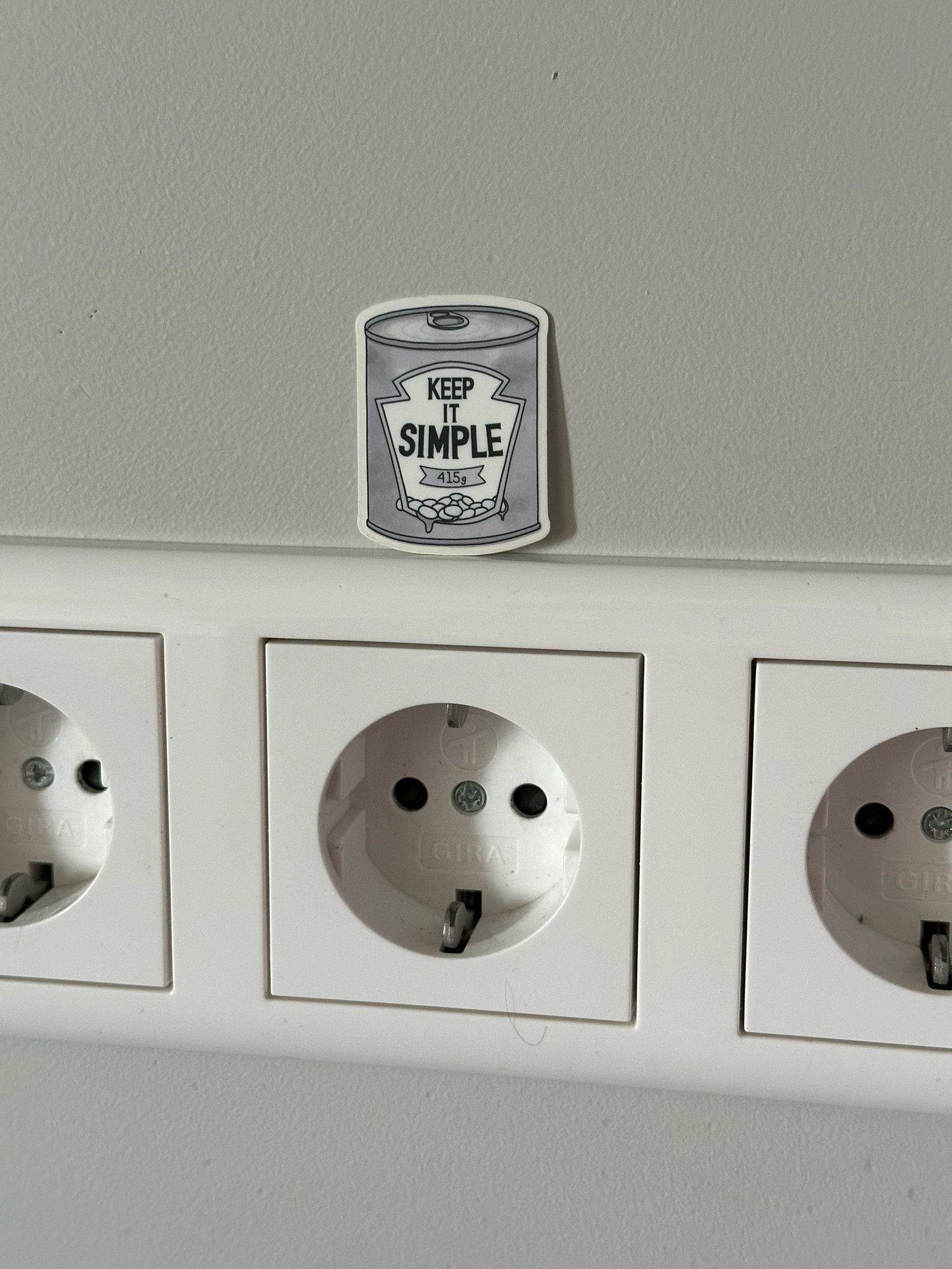 A Keep It Simple sticker above a row of wall sockets